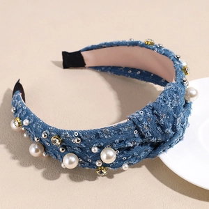 Detail of blue denim headband featuring white pearls, sparkling rhinestones, and top knot