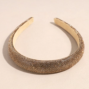 Détail d'un serre-tête doré champagne orné de strass brillants avec doublure intérieure douce