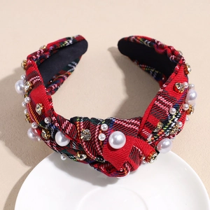Detail of red plaid headband with embedded faux pearls and rhinestones on fabric