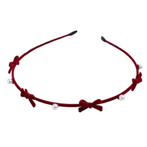 Elegant red velvet headband with pearl and bow accents for women's stylish hair styling