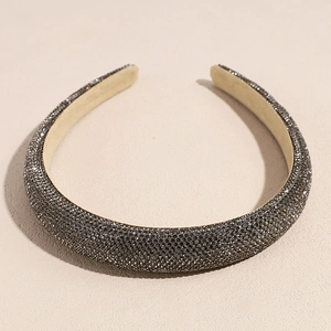 Gros plan détaillé d'un serre-tête rembourré avec strass gris brillants et doublure beige