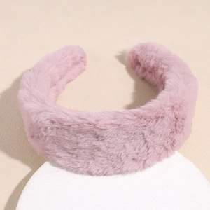 Close-up of soft pink plush wide headband with fluffy faux fur texture on white display