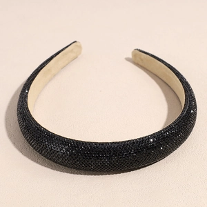 Détail d'un serre-tête large en strass noirs avec doublure beige antidérapante et luxe