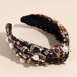 Close-up of black tweed headband with colorful weave, white pearls, and clear rhinestones