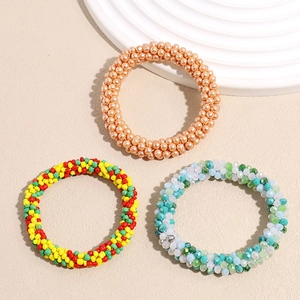 Three elegant beaded elastic hair ties in champagne gold, multicolor and blue tones