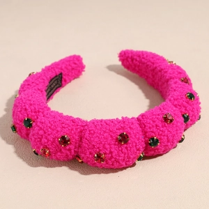 Close-up of pink plush headband featuring sparkling red and green rhinestone embellishments