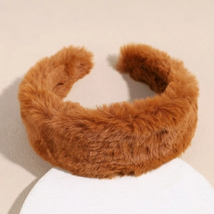 Close-up of thick brown plush headband with soft faux fur texture on a white display pedestal