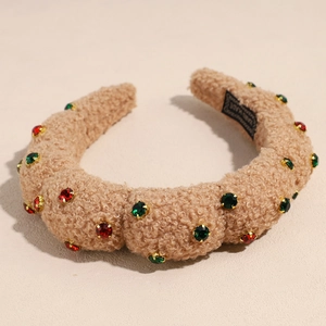 Detail of khaki teddy plush headband with red and green rhinestones and hand made label