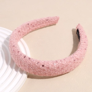 Détail d'un serre-tête tressé rose en éponge avec paillettes et doublure antidérapante