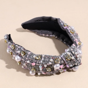 Detailed view of tweed knotted headband with white faux pearls and sparkling rhinestones