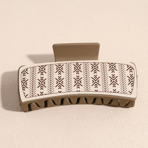 Detail of vintage brown PU leather hair claw clip with geometric arrow patterns