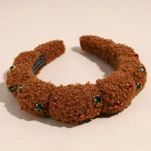 Detailed close-up of brown plush headband featuring red and green rhinestones