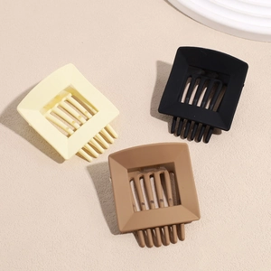 Three-piece set of matte geometric hair claws in cream, black, and mocha colors