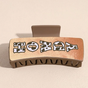 Detail of vintage brown PU leather shark hair claw with HOLLY cow print lettering design