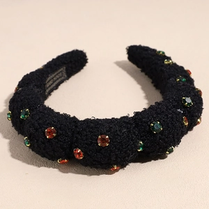 Detail of plush black headband with luxury red and green rhinestones and handmade label