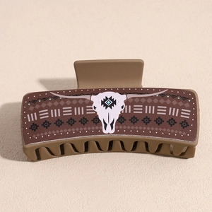 Detail of khakhi hair claw clip featuring a bohemian bull skull and geometric pattern
