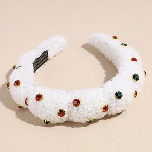 Detail shot of white plush headband featuring festive colorful rhinestones and handmade label