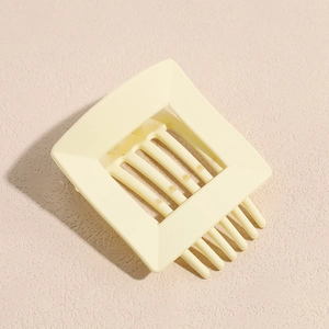 Detailed view of cream yellow square hollow hair claw clip with geometric french vintage design
