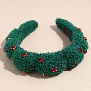 Detailed close-up of plush dark green headband with red and green rhinestones and label