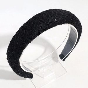 Gros plan du serre-tête en tweed noir avec paillettes et structure rembourrée
