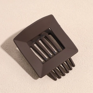 Detail of coffee brown matte square hair claw clip with a hollow geometric design