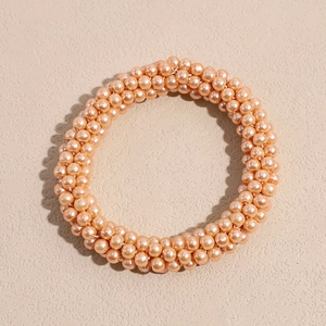 Detailed close-up of woven cream pearl hair tie with a soft lustrous finish