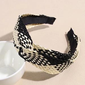 Detail of bohemian woven headband with cross knot design in champagne and black pattern