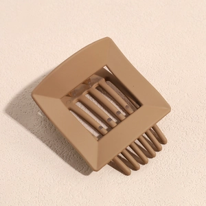 Detailed macro view of a matte brown square hollow hair claw clip for elegant styling
