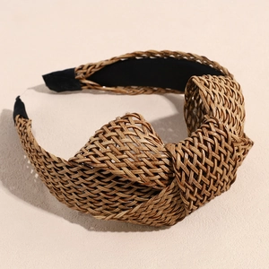 Detailed view of bohemian straw woven headband featuring a top knot and black inner lining