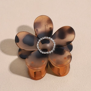 Detail of tortoise shell flower hair claw clip with sparkling rhinestones decoration