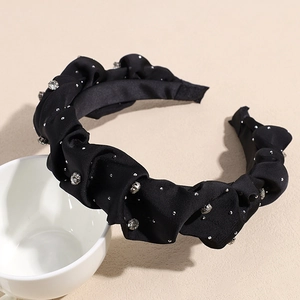 Dettaglio del cerchietto plissettato in raso nero con strass luminosi ed eleganti