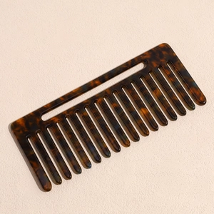 Détail d'un peigne démêlant à dents larges avec un motif marbré ambre élégant