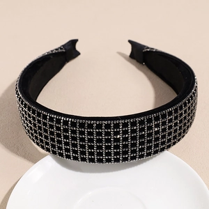Detailed view of black velvet headband with sparkling silver rhinestone grid patterns