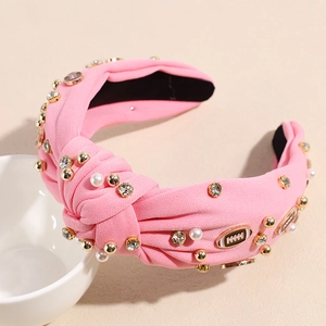 Detailansicht des rosa Stoffstirnbands mit Perlen, Strass und goldenen Football-Anhängern