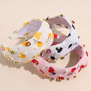 Pink and white wide knotted headbands with hearts, pearls, and colorful rhinestones