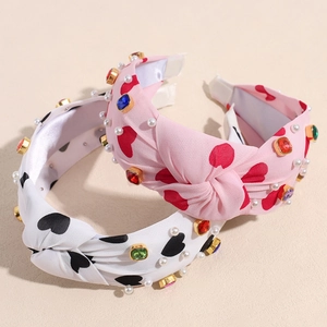 Pink and white knotted fabric headbands with heart prints, rhinestones and pearls