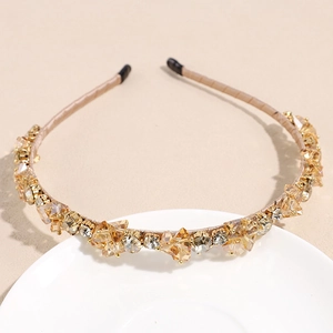 Détail du serre-tête en cristaux champagne avec strass brillants sur plateau céramique