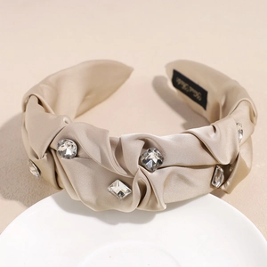 Detailaufnahme von Champagner-Satin-Haarreif mit Strasssteinen und Handarbeits-Etikett