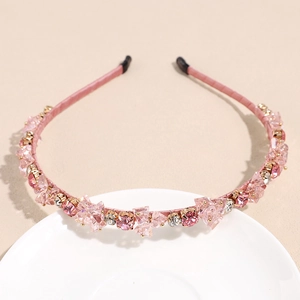 Détail du serre-tête en cristal rose avec revêtement satiné et griffes en métal