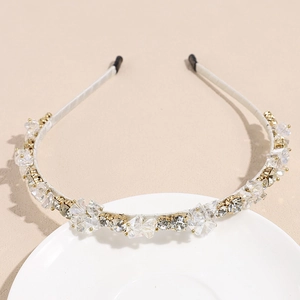 Détail des strass en cristal sur un serre-tête fin en métal recouvert de satin