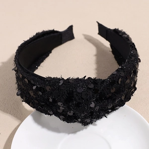 Detailed close-up of a black sequined knotted headband with elegant velvet texture