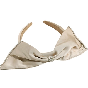 Serre-tête en satin doré champagne avec grand nœud en strass et détail perle