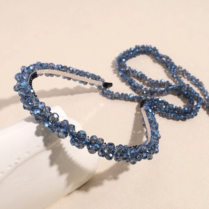 Detail of handcrafted navy blue faceted crystal beads woven on a silver hairband