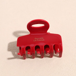 Macro shot of bright red hair claw clip with golden Barrette La France text and glossy finish