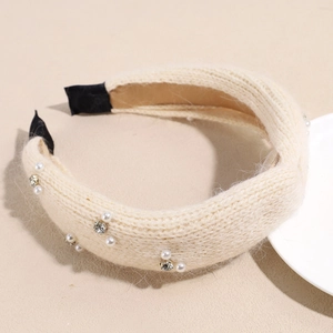 Detailaufnahme des cremefarbenen Strickstirnbands mit Perlen, Strass und Wollstruktur