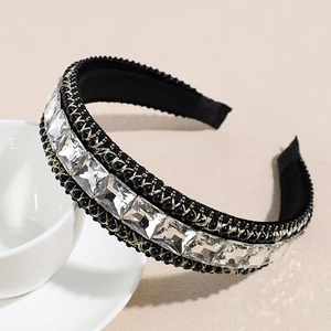Detail of baroque black velvet headband with large crystals and pearls on beige background