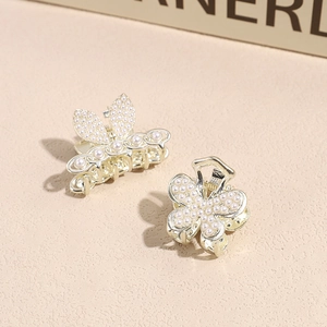 Elegantes Set aus goldenen Schmetterlings-Haarklammern mit weißen Perlen und Strasssteinen