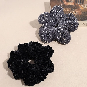Chouchous élégants en velours à paillettes noir et gris sur fond esthétique épuré