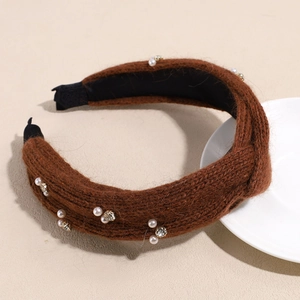 Details des braunen Strickstirnbands mit Perlen und funkelnden Strasssteinen