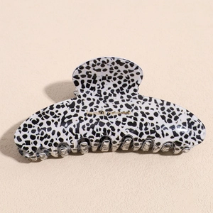 Detail of Dalmation pattern acetate hair claw with gold label and metal spring